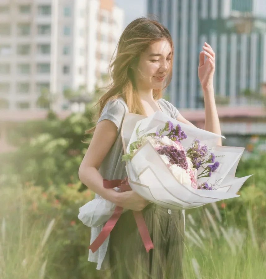 นางแบบถือช่อดอกไม้กลางสวน